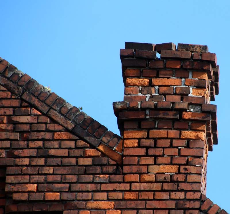 Damaged chimney on an Coppell home showing cracks and missing mortar